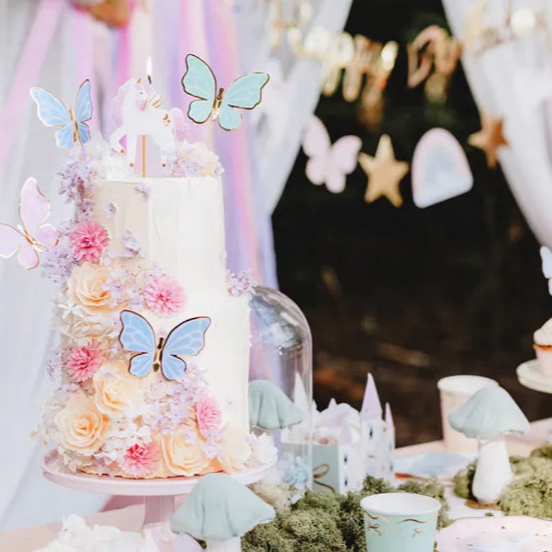 Vela de unicornio sobre pastel con flores decoradas.