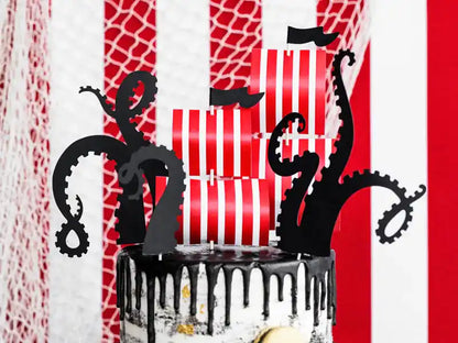 Toppers piratas de colores variados sobre mesa de dulces para celebración