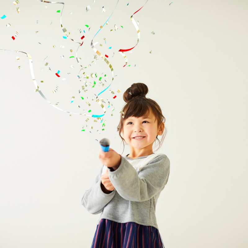 cañón confeti de colores lanzado por una niña