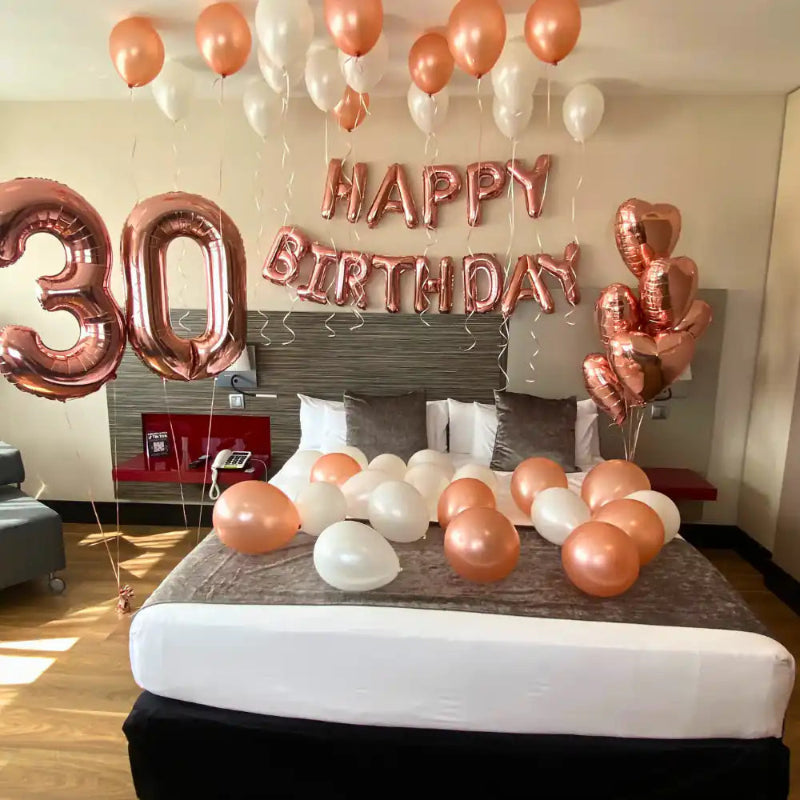 Decoración cumpleaños luxury en habitación de hotel Barcelona con globos látex, números 86cm y corazones foil