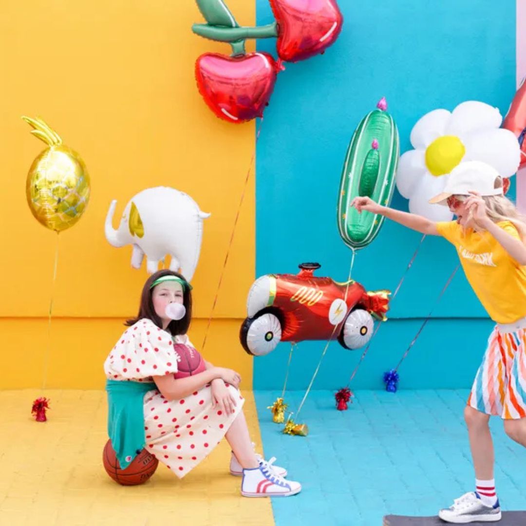 niñas jugando con globos de aluminio con diseño de elefante, flor, cerezas.