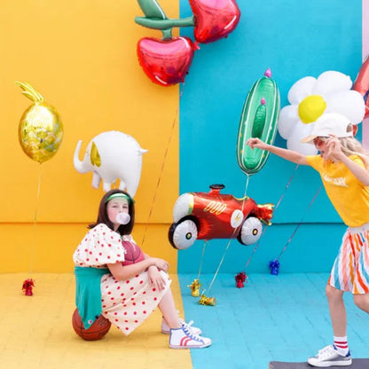 niñas jugando con globos de aluminio con diseño de elefante, flor, cerezas.